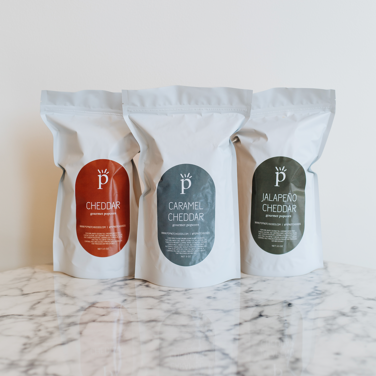 Cheesy Goodness Sampler Pack includes Cheddar popcorn, Jalapeño Cheddar popcorn, and Caramel Cheddar popcorn. This sampler pack makes a great gift or eases decision making. Popnotch Goods is located in Grand Rapids Michigan on Wealthy Street. Grand Rapids Popcorn.
